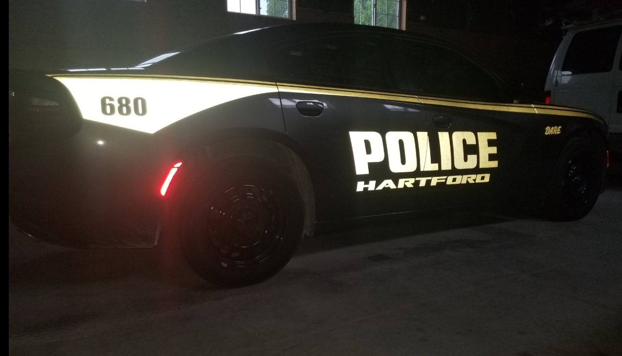Hartford police car with reflective door lettering glowing at night